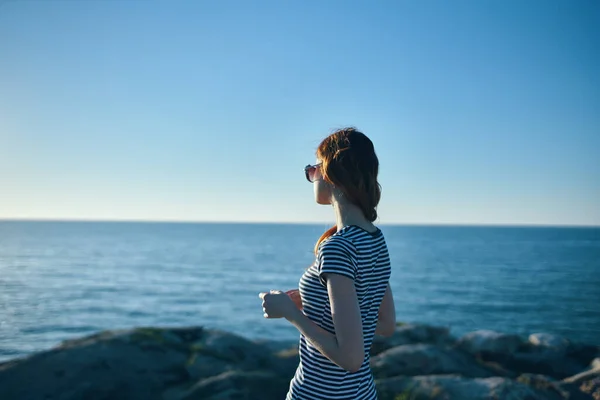 Woman outdoors in the mountains looking at the sea beach summer vacation landscape — Stock Photo, Image