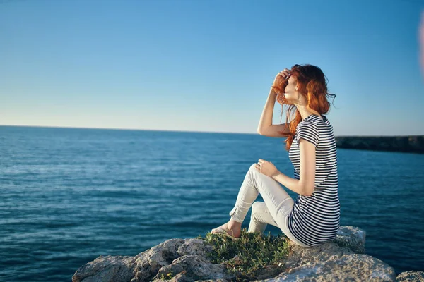 Happy traveler on the beach near the sea in the mountains in summer and clear water — Stock Photo, Image