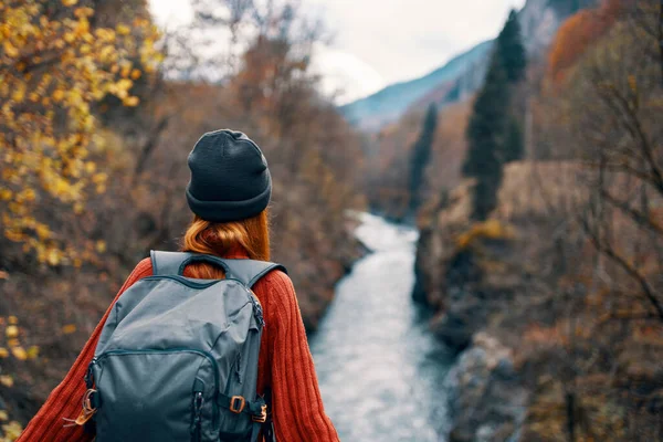 Femme randonneur avec un sac à dos sur le dos près d'une rivière de montagne dans la nature, vue arrière — Photo