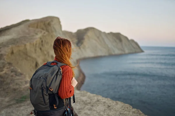 Романтичний мандрівник з рюкзаком в горах на природі захід сонця і моря на задньому плані — стокове фото