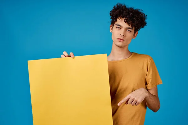 guy in yellow t-shirt poster mockup advertising blue background