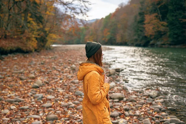Vrouw in het bos rivier gevallen bladeren reizen landschap — Stockfoto