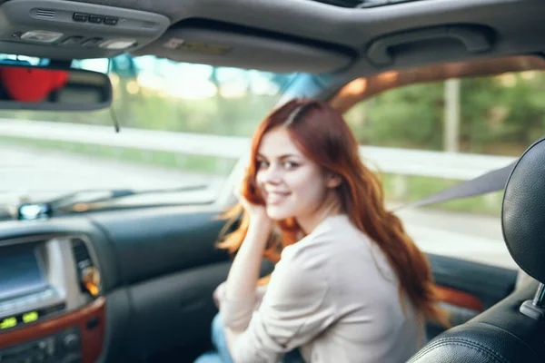 Mujer compañero de viaje en un salón de coches en el diseño del asiento delantero ventana abierta naturaleza — Foto de Stock