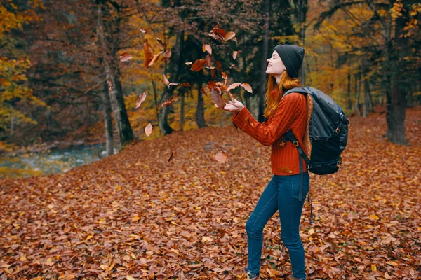Vrouw in een trui hoed jeans 3 wet op de rug en de natuur in de achtergrond bomen bos model — Stockfoto