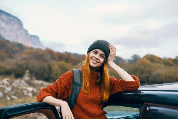 Žena turistka s batohem v blízkosti auta na horském výletě — Stock fotografie