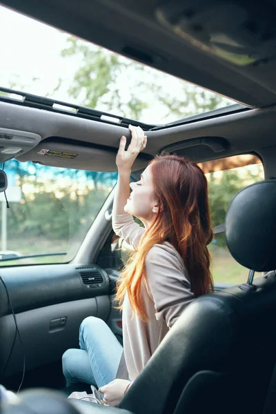 Mulher companheiro viajante em um salão de carro no projeto do banco da frente janela aberta natureza — Fotografia de Stock