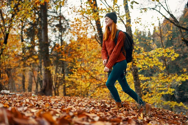 Beautiful woman with a backpack in the park on nature landscape fallen leaves bottom view — Stock Photo, Image