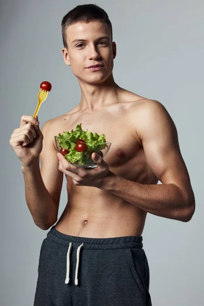 Atletický muž s svalnatým trupem talíř se salátovou dietou cvičení — Stock fotografie