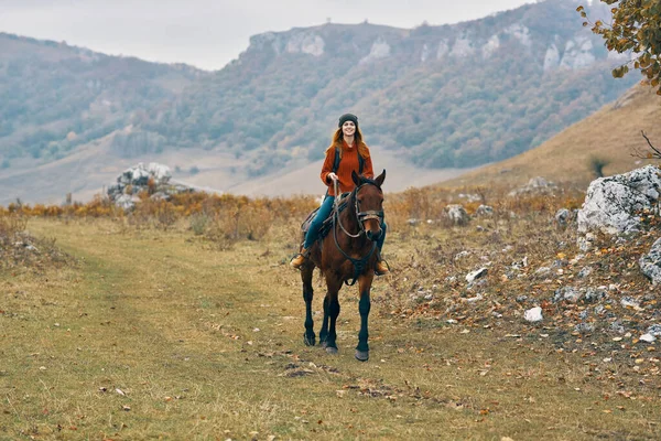 Mulher caminhante nas montanhas montando um estilo de vida de aventura de cavalo — Fotografia de Stock