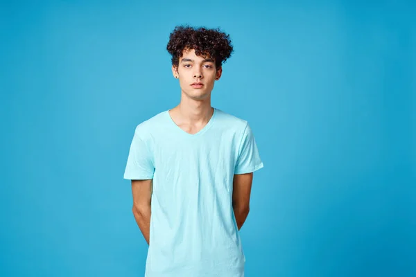 Roztomilý chlap kudrnaté vlasy modré tričko izolované pozadí — Stock fotografie