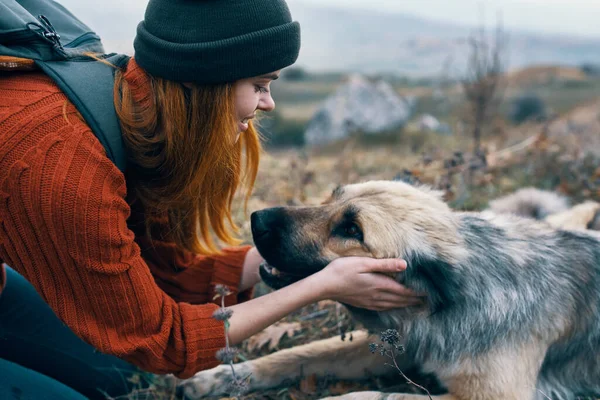 Mujer con mochila en la naturaleza se juega con perro viaje paisaje —  Fotos de Stock