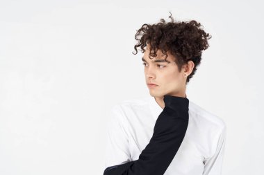 Açık arkaplan, kıvırcık saç modeli üzerinde gömlek ve ceket giyen yakışıklı bir adam.