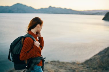 Sırtına kilitlenen güzel bir kadın. Turizm, dağları aşar. Gün batımı modeli.