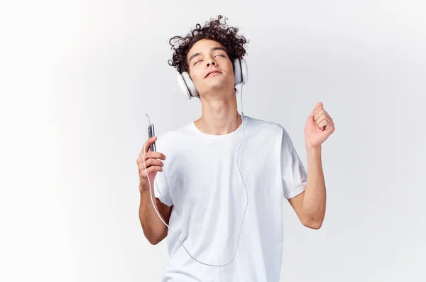 Hombre emocional en camiseta blanca escuchando música con auriculares vista recortada —  Fotos de Stock