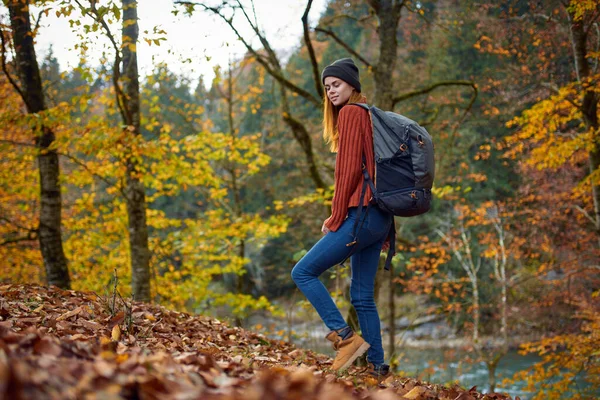 Wanderin mit Rucksack spaziert im Herbst im Park in der Natur — Stockfoto