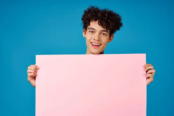 Émotionnel gars avec poster rose maquette fond bleu — Photo