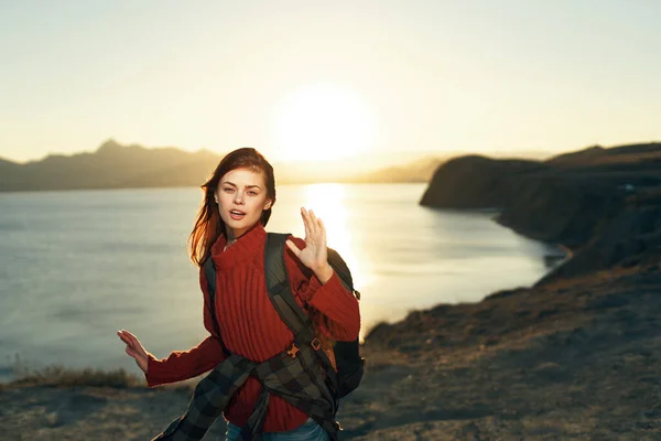 Весела жінка ходить по скелястих горах пейзаж захід сонця свіже повітря — стокове фото