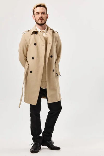Мужчина с серьезным выражением бежевого пальто моды современный стиль в полную длину — стоковое фото
