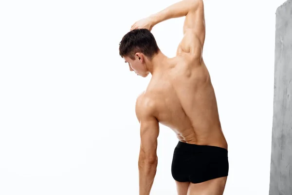 身体の体操をしてる男が孤立した背景で裸体の胴を持つ — ストック写真