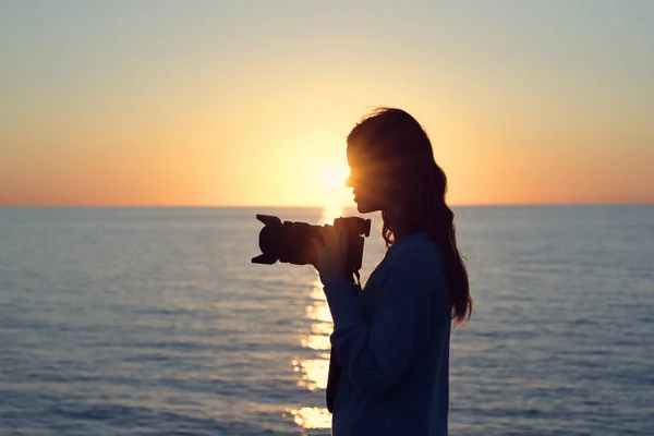 夕阳西下时一个带着相机的女人的侧影 — 图库照片