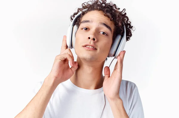 Een man in een wit t-shirt met hoofdtelefoon luistert naar muziekemoties genot — Stockfoto