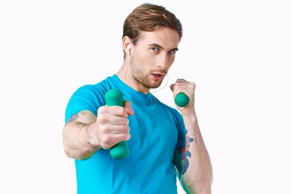 Man i blå t-shirt med hantlar i handen tatuering fitness träning — Stockfoto