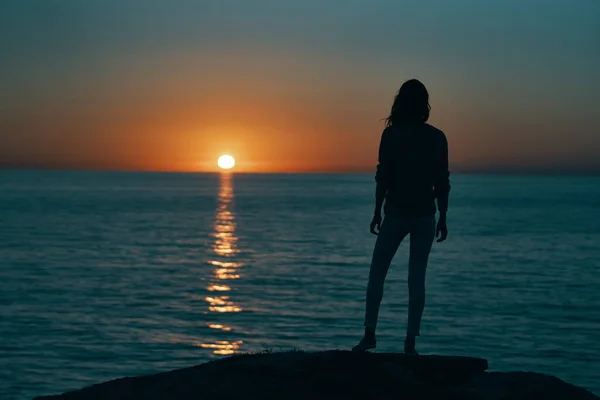 海岸とビーチの空に沈む夕日の海のシルエットの女性 — ストック写真