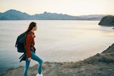 Sırtına kilitlenen güzel bir kadın. Turizm, dağları aşar. Gün batımı modeli.