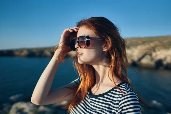 Viajero feliz en gafas y camisetas cerca del mar en las montañas cielo azul vista lateral de verano — Foto de Stock