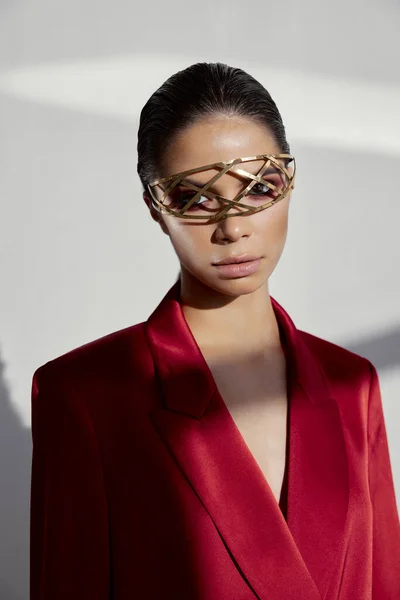Portret van stijlvolle vrouw in rode jas en sieraden op haar gezicht — Stockfoto