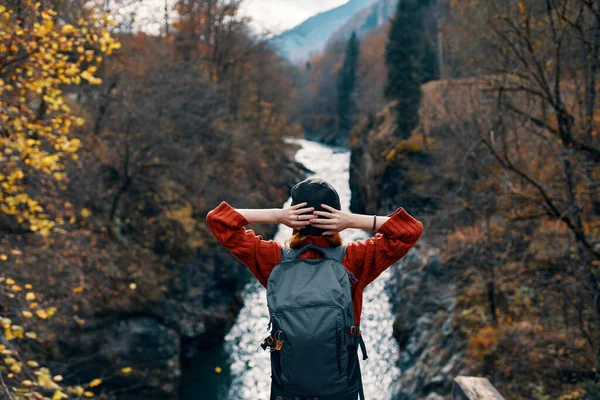 Femme touriste se tient sur le pont sur la rivière ou admire le paysage naturel — Photo