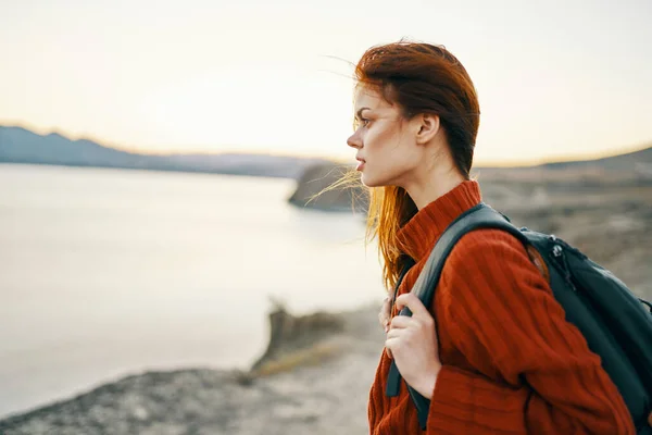 Donna turista in maglione con zaino in autunno in montagna vicino al mare — Foto Stock