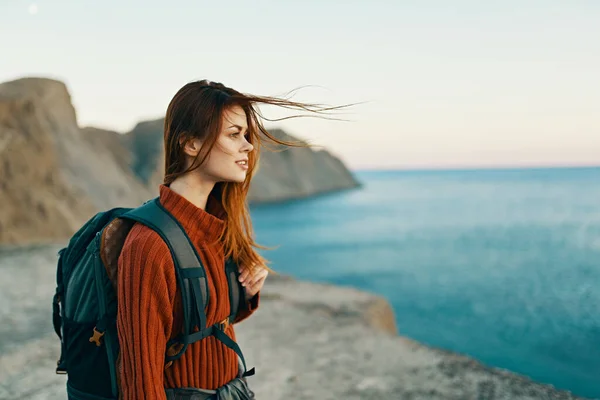 Hübsche Frau in Verbindung mit einem Rucksack auf dem Rücken in den Bergen in der Nähe des Meeres Seitenansicht Modell — Stockfoto