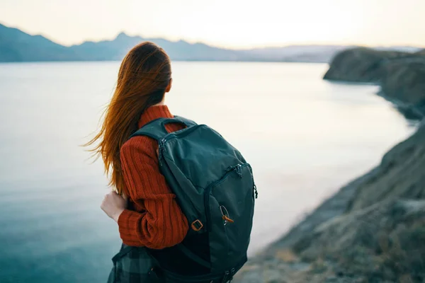 Donna in maglione rosso con zaino e turismo di viaggio mare montagne vista posteriore — Foto Stock