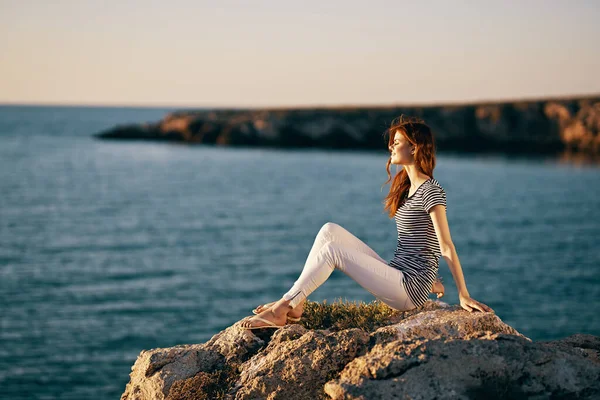Donna in montagna siede sulla riva del mare paesaggio naturale — Foto Stock