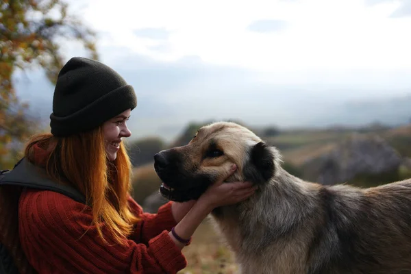 Cheerful woman next to a dog outdoors vacation friendship — Stock Photo, Image