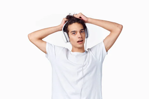 Man met krullend haar luisteren naar muziek met hoofdtelefoon tiener mode nieuwe technologie t-shirt — Stockfoto