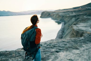 Kadın turist şehri geziyor, deniz manzaralı jestler yapıyor.