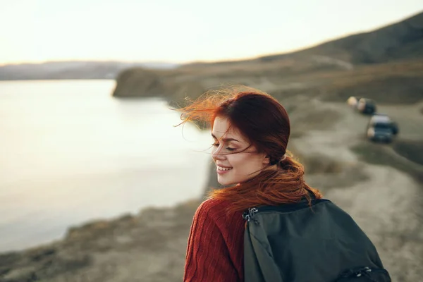 Ritratto di donna con zaino sulla natura in montagna vicino al mare al tramonto vista ritagliata — Foto Stock