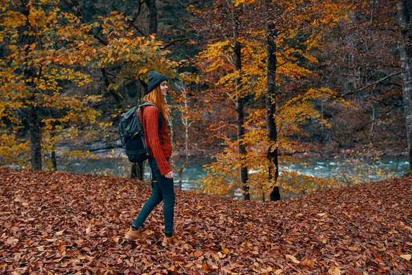 Žena v plném růstu procházky v parku na podzim v přírodě v blízkosti řeky — Stock fotografie