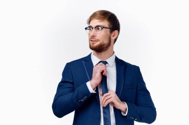 Beyaz gömlekli iş adamı ceketini ve sakalını düzeltiyor.