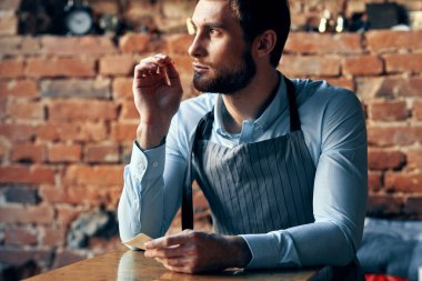 Kafe tuğlalı duvar müşterilerinin menüsünde bir şef. İç oda içeceği bardağı.