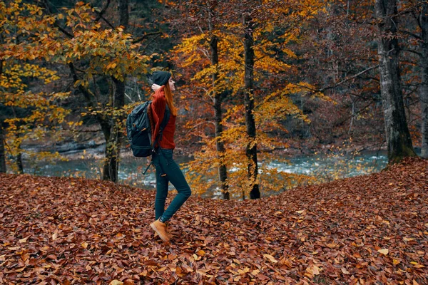 Podróżnik z plecakiem spacery w parku w przyrodzie w pobliżu rzeki jesienią — Zdjęcie stockowe