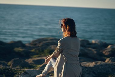 Kadın nehir kıyısında, dağlarda, kumsalda yaz manzarası, temiz hava.