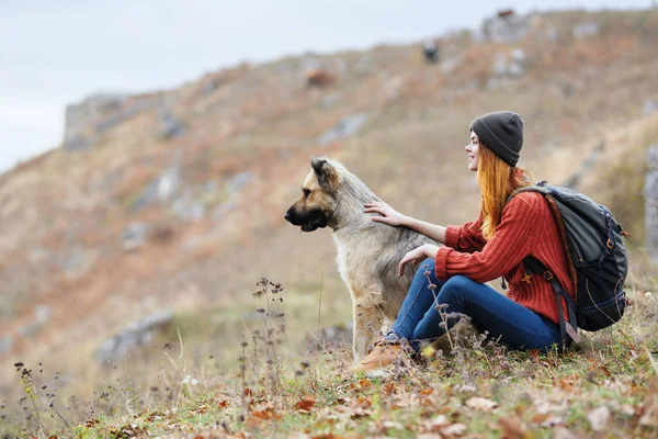 Glad kvinna vandrare i bergen utomhus bredvid hunden resa semester — Stockfoto