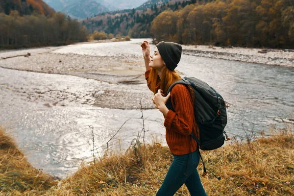 Mujer en otoño en las montañas con una mochila sobre sus hombros viajar turismo río —  Fotos de Stock