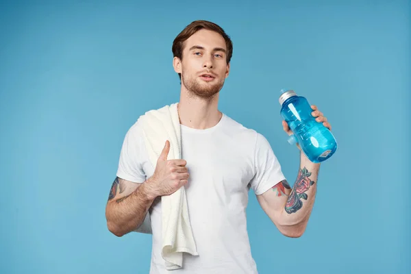 Σπορ άνθρωπος δείχνει τον αντίχειρα μέχρι πετσέτα μπουκάλι νερό στον ώμο περικοπεί προβολή μπλε φόντο — Φωτογραφία Αρχείου