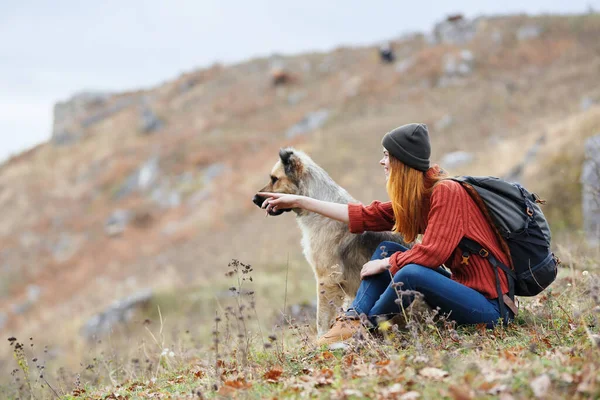 Cheerful woman hiker in the mountains outdoors next to the dog travel vacation — Stock Photo, Image