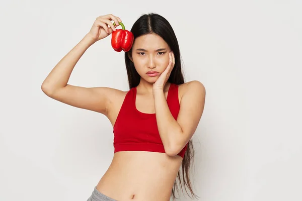 Mujer en ropa deportiva con pimienta roja en su dieta de la mano calorías estricta adherencia —  Fotos de Stock