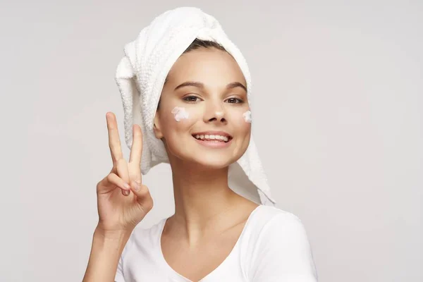 頭にタオルをつけた女性は積極的なジェスチャーときれいな肌の美容皮膚科モデルを示しています — ストック写真